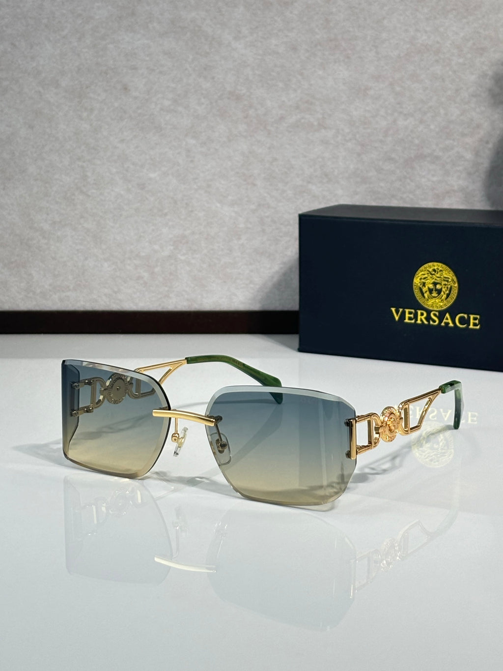 Versace sunglasses with gold frame and green-tinted lenses, three-quarter view