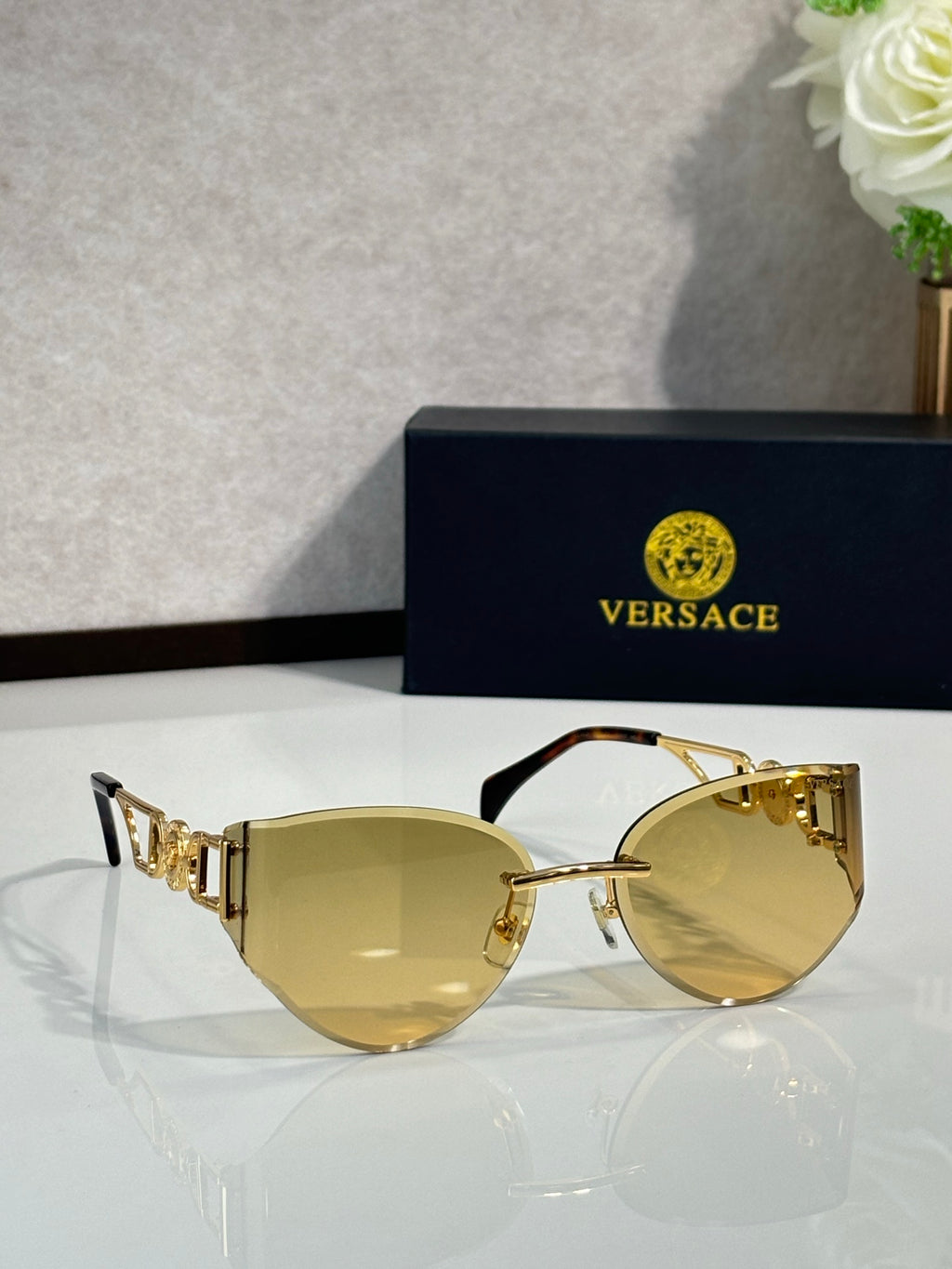 Versace gold metal aviator sunglasses with pale yellow lenses and square logo temple details