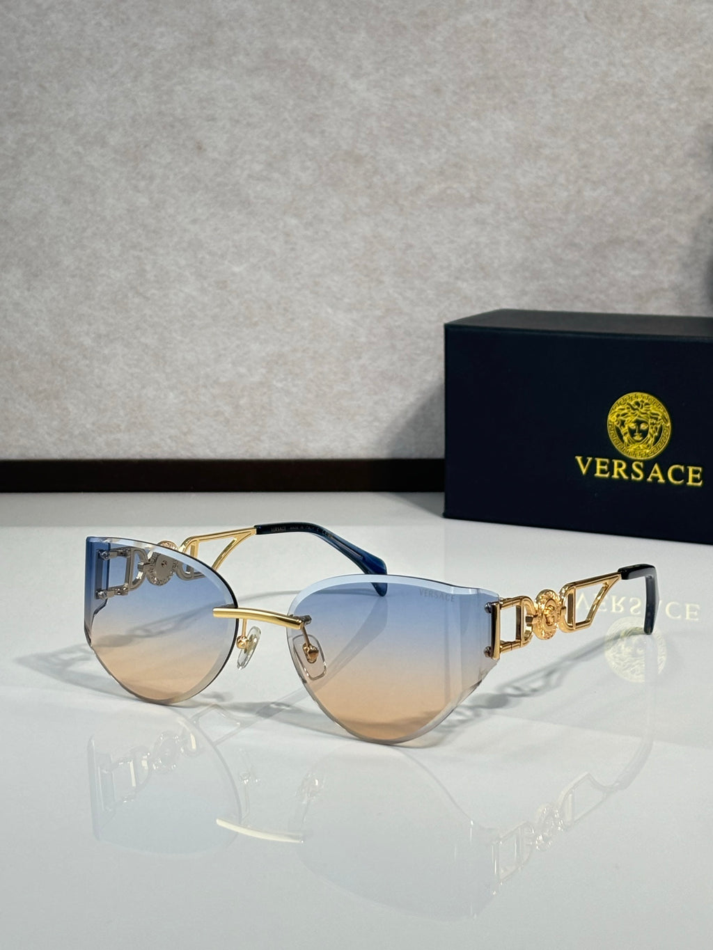Versace gold metal aviator sunglasses with gradient tinted lenses and logo detail temples
