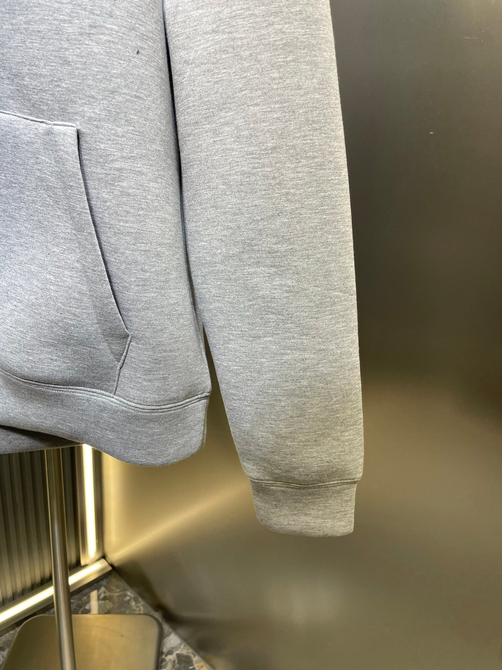 Light gray Gucci hoodie cuff with sleeve end and front pocket corner