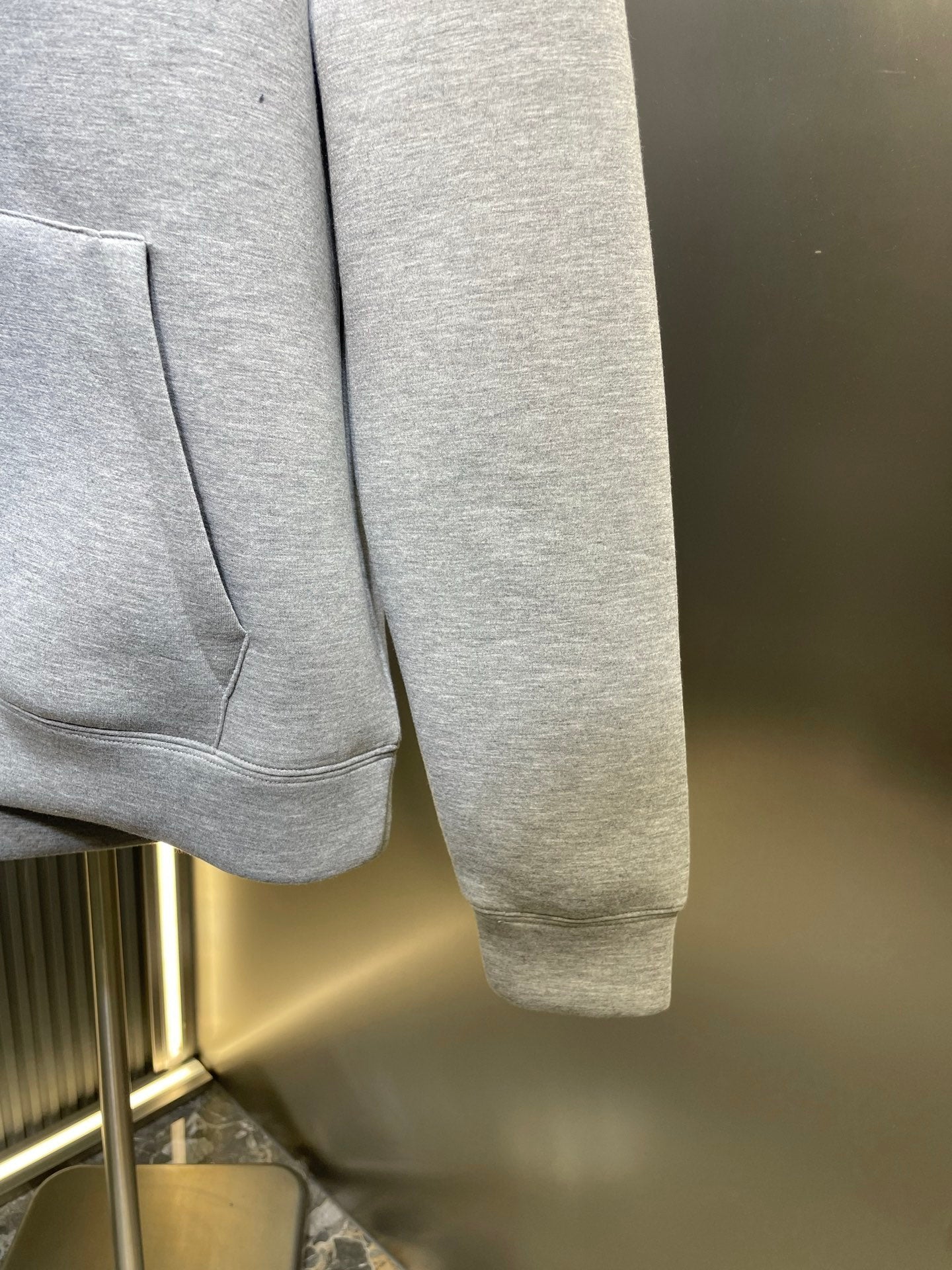 Light gray Gucci hoodie cuff with sleeve end and front pocket corner