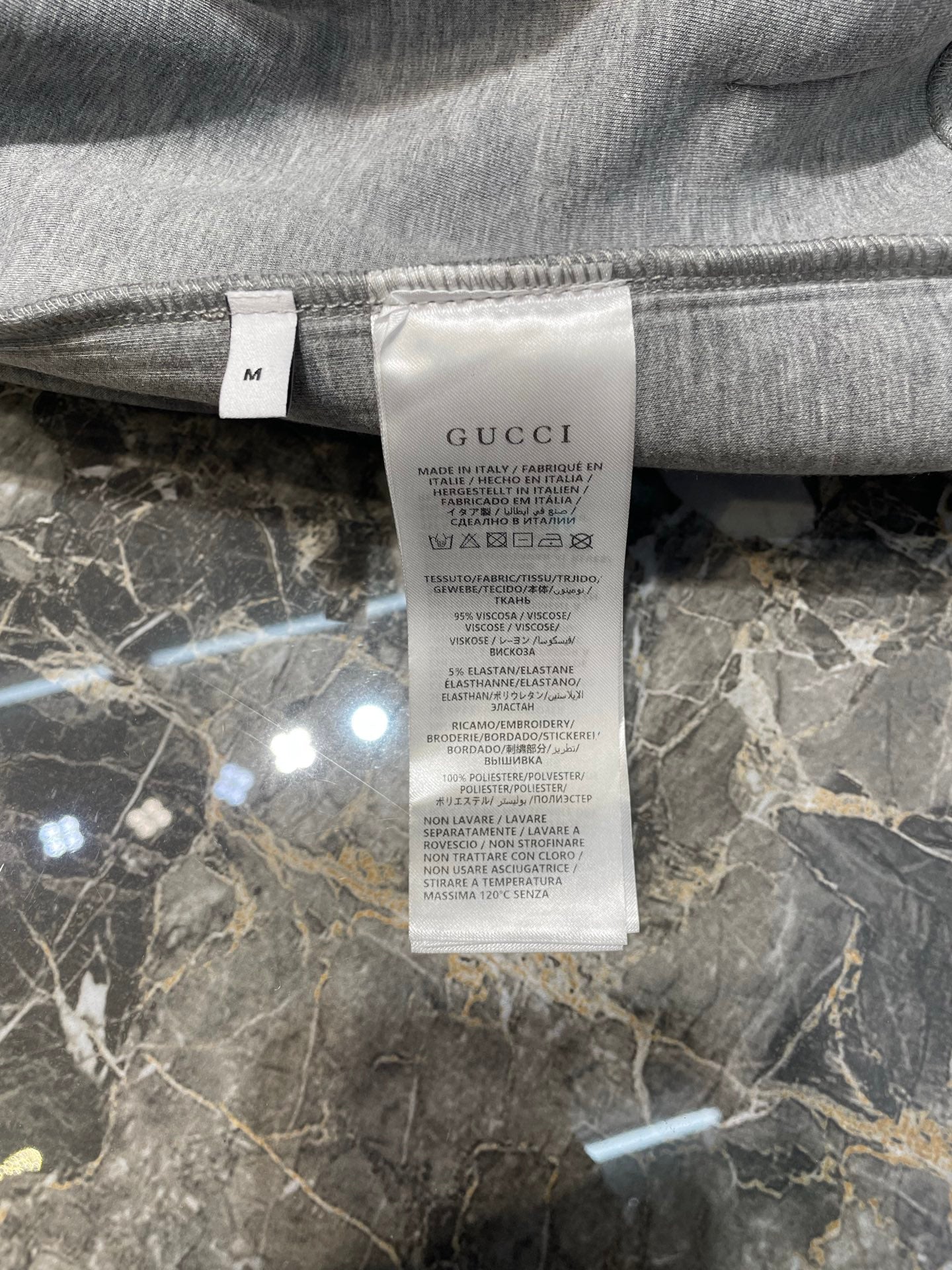 Light gray Gucci hoodie size and care label inside neckline