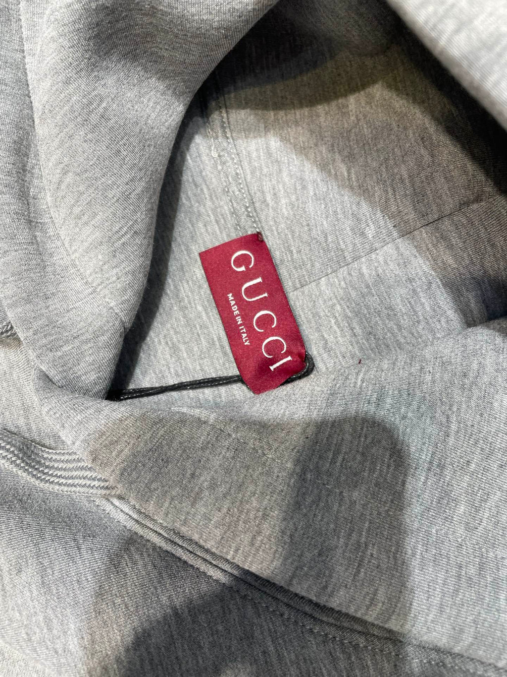 Light gray Gucci hoodie fabric with red Gucci neck label