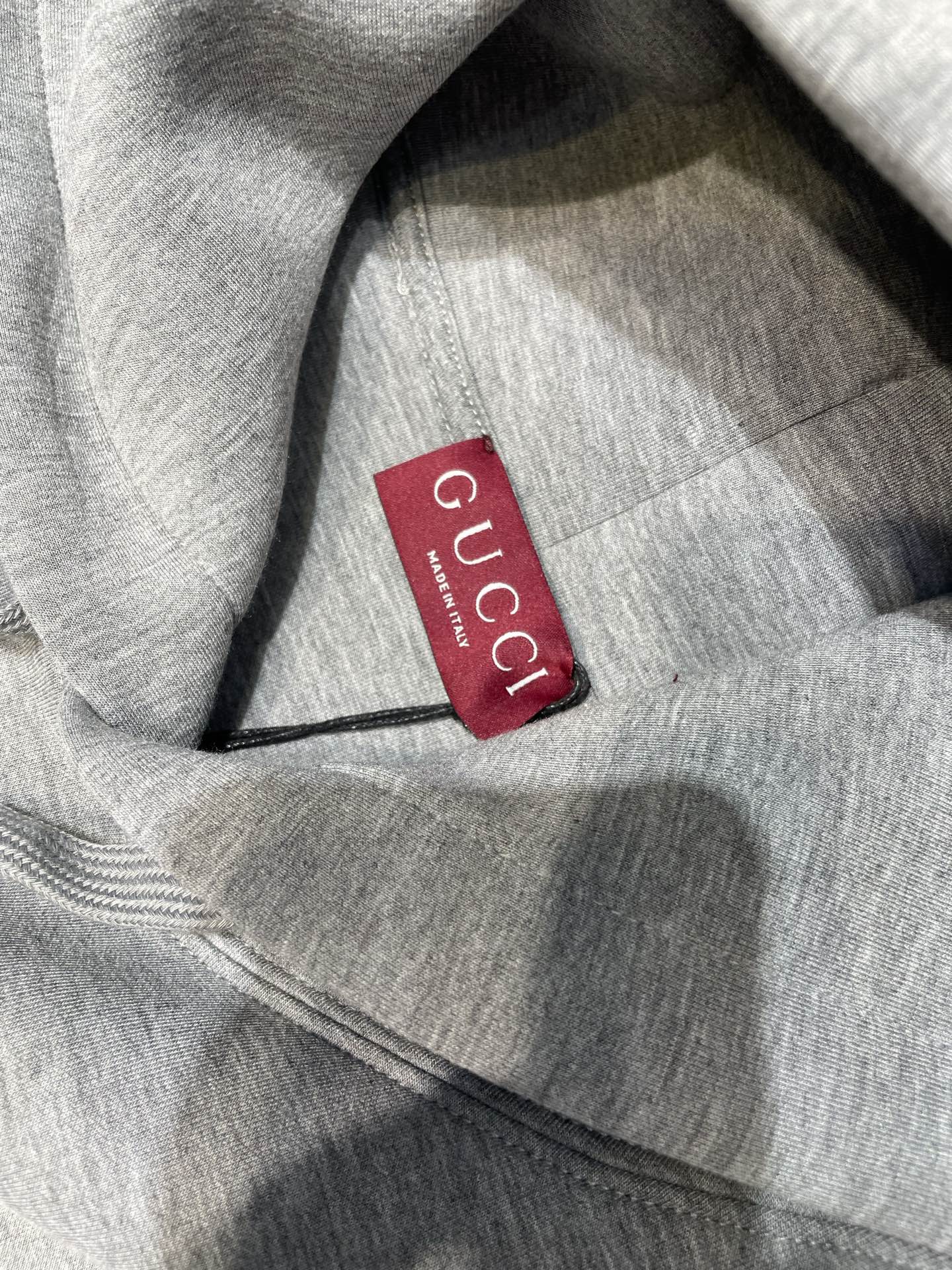 Light gray Gucci hoodie fabric with red Gucci neck label