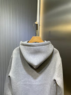 Light gray Gucci hoodie with back hood and seam details, hanging on stand