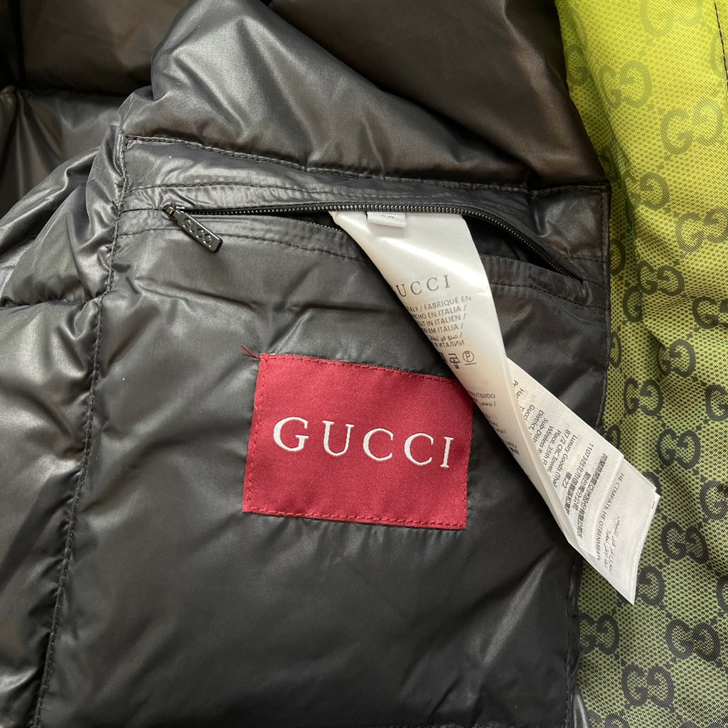 Gray padded jacket interior pocket with red GUCCI label and white tag