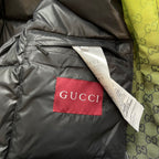 Gray padded jacket interior pocket with red GUCCI label and white tag