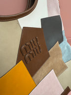 Patchwork tote bag front detail, logo embossing on brown leather patch