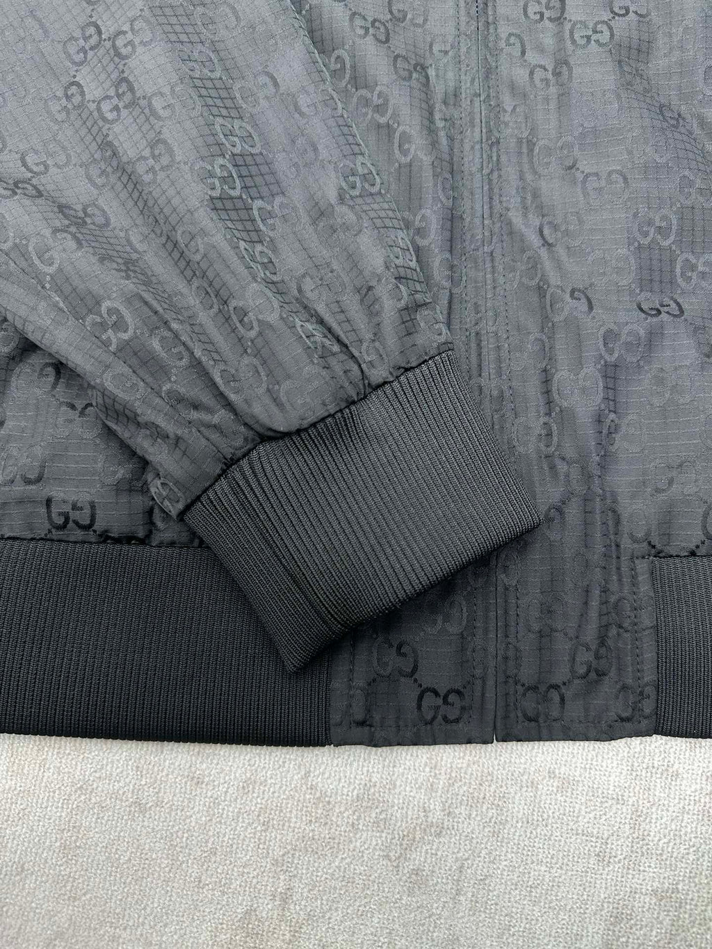 Gucci dark GG-pattern sleeve with ribbed knit cuff and textured panel