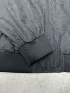 Gucci dark GG-pattern sleeve with ribbed knit cuff and textured panel