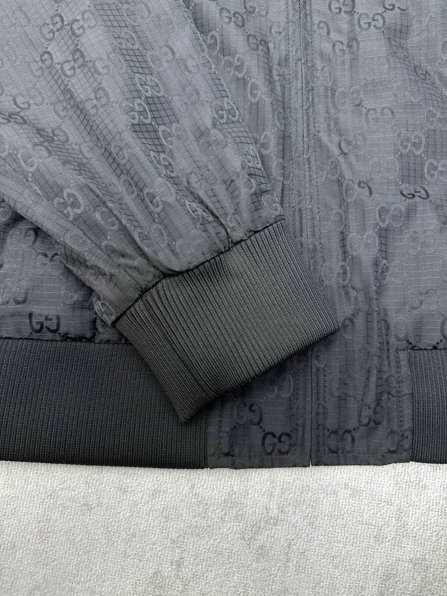 Gucci dark GG-pattern sleeve with ribbed knit cuff and textured panel