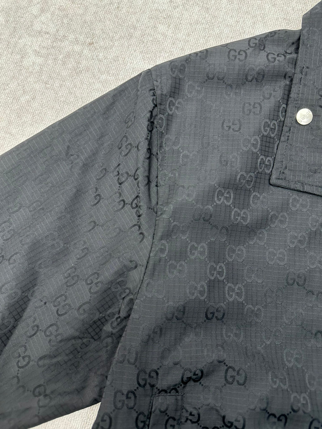 Gucci dark GG-pattern jacket with snap shoulder button and zip placket