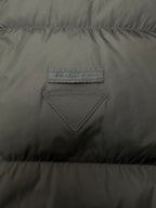 Black puffer vest chest with triangular stitched logo patch