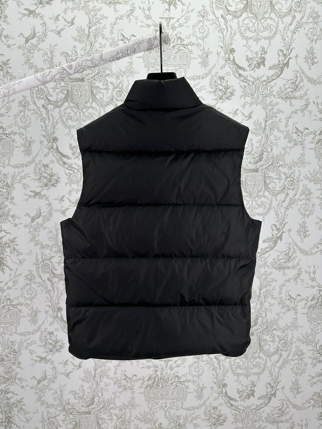 Back view of black sleeveless puffer vest with horizontal quilting