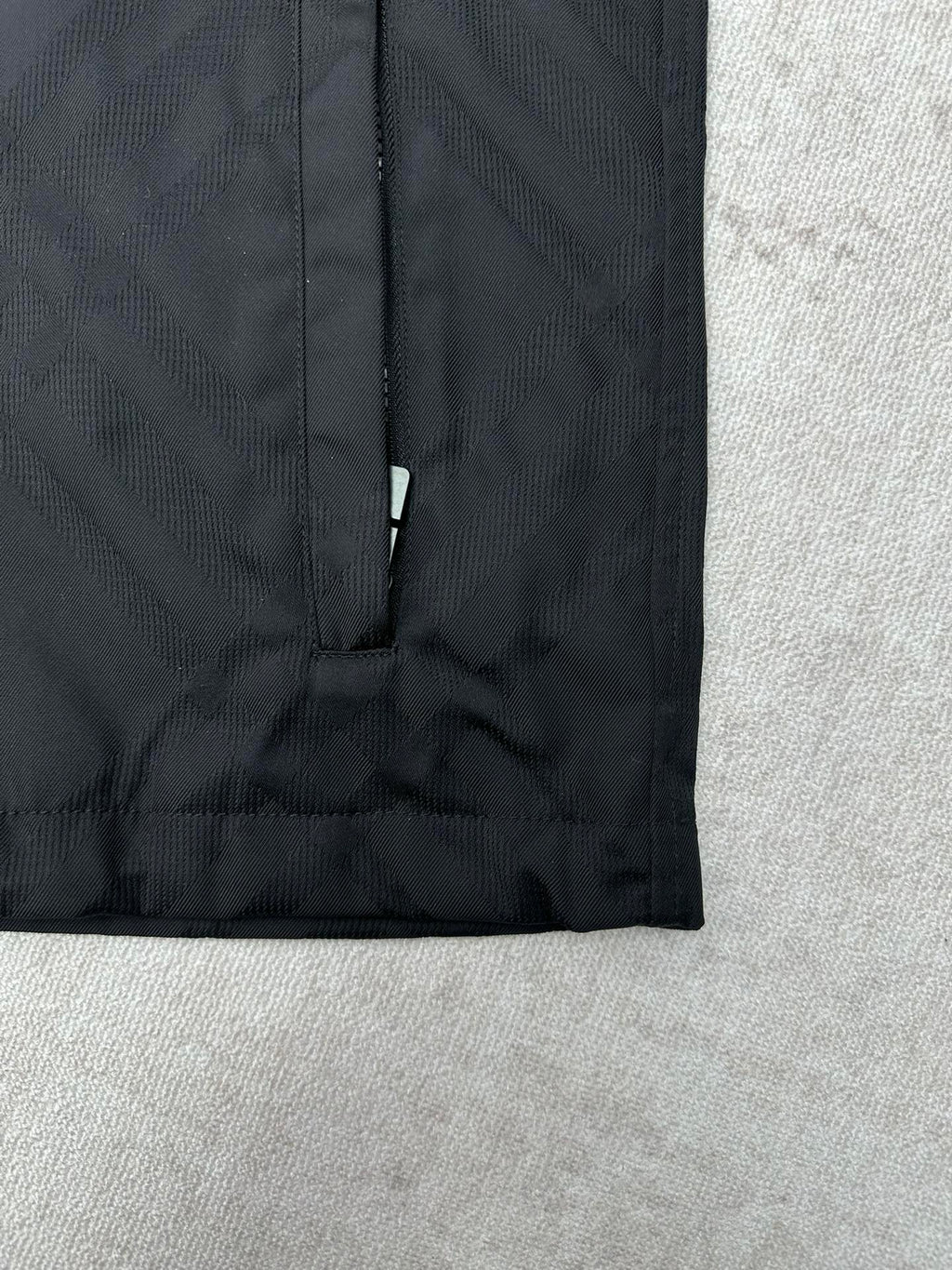 Dark puffer jacket lower front with vertical zipper and clean hem