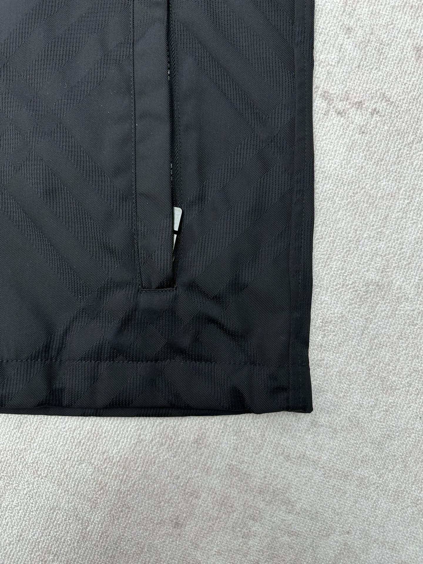 Dark puffer jacket lower front with vertical zipper and clean hem