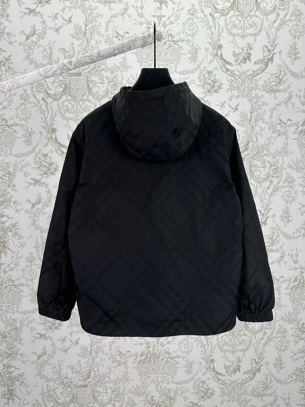 Hooded puffer jacket back view with raised hood, dark color