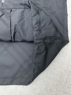 Lower front of dark puffer jacket with stitched panels and zipper area
