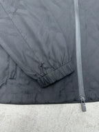 Sleeve cuff with elastic hem and zipper seam on a dark puffer jacket