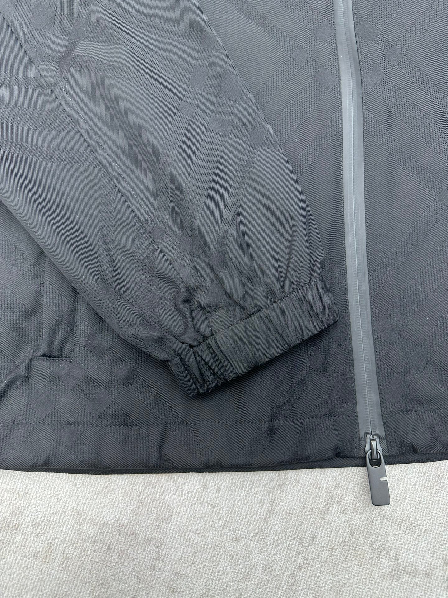 Sleeve cuff with elastic hem and zipper seam on a dark puffer jacket
