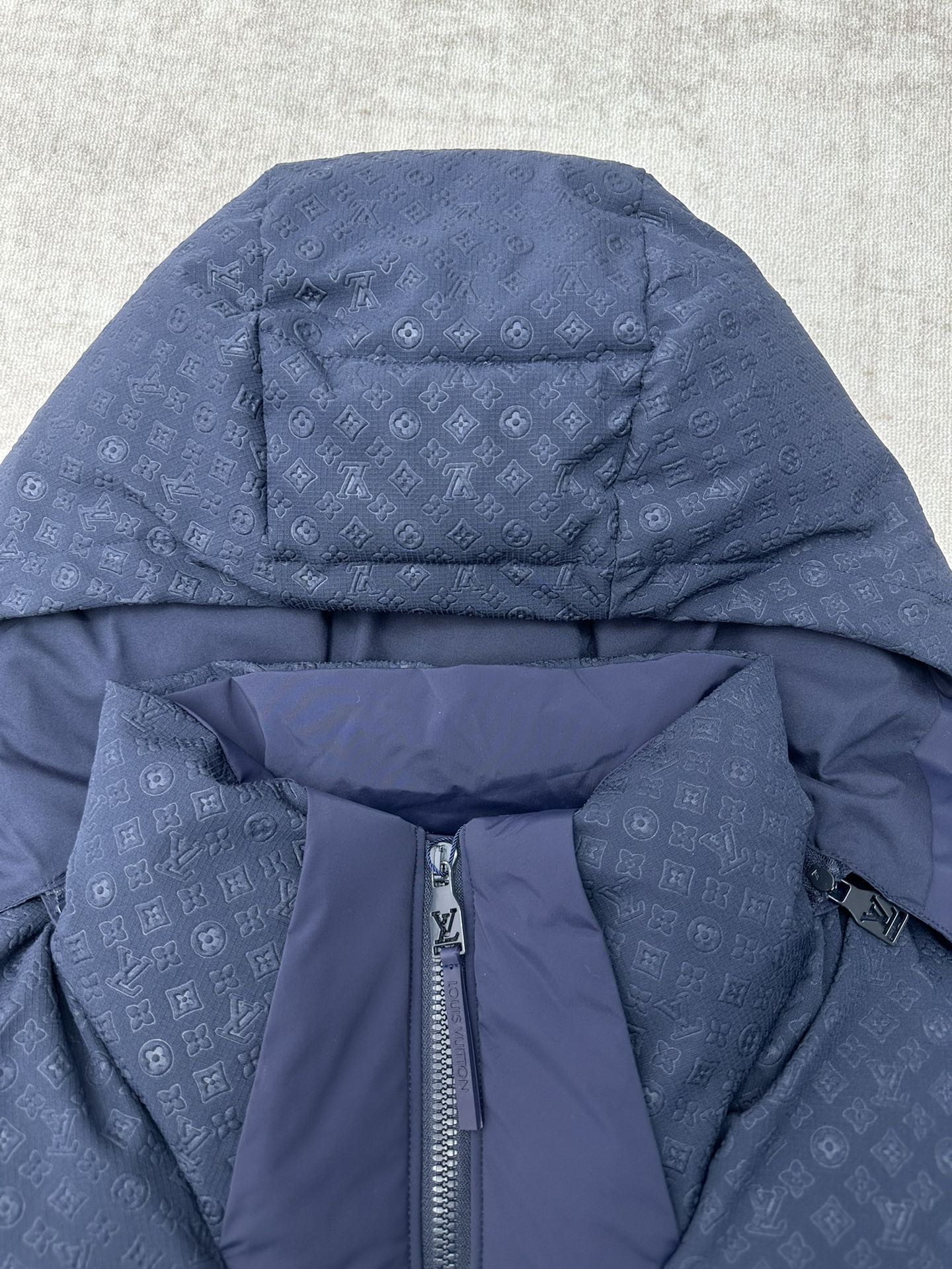 Long hooded puffer jacket detail with front zipper, dark blue