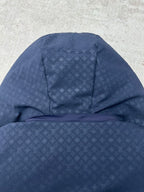 Long hooded puffer jacket view with textured monogram-style pattern, dark blue