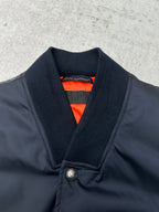 Navy bomber jacket with ribbed V-neck collar and bright orange inner lining