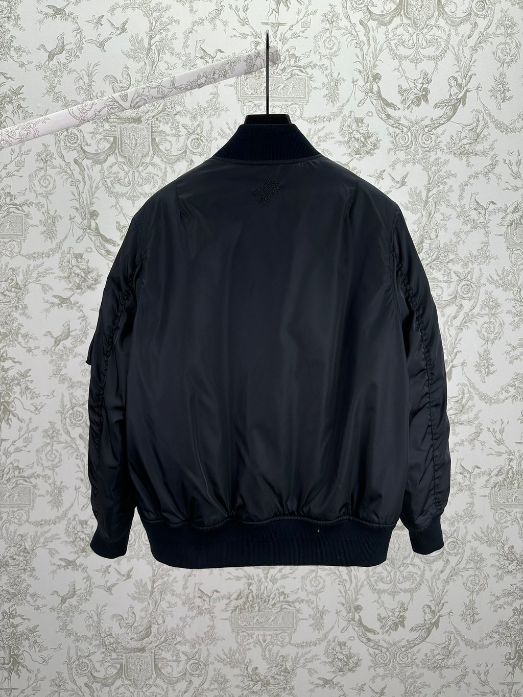 Navy bomber jacket back view with ribbed cuffs and waistband