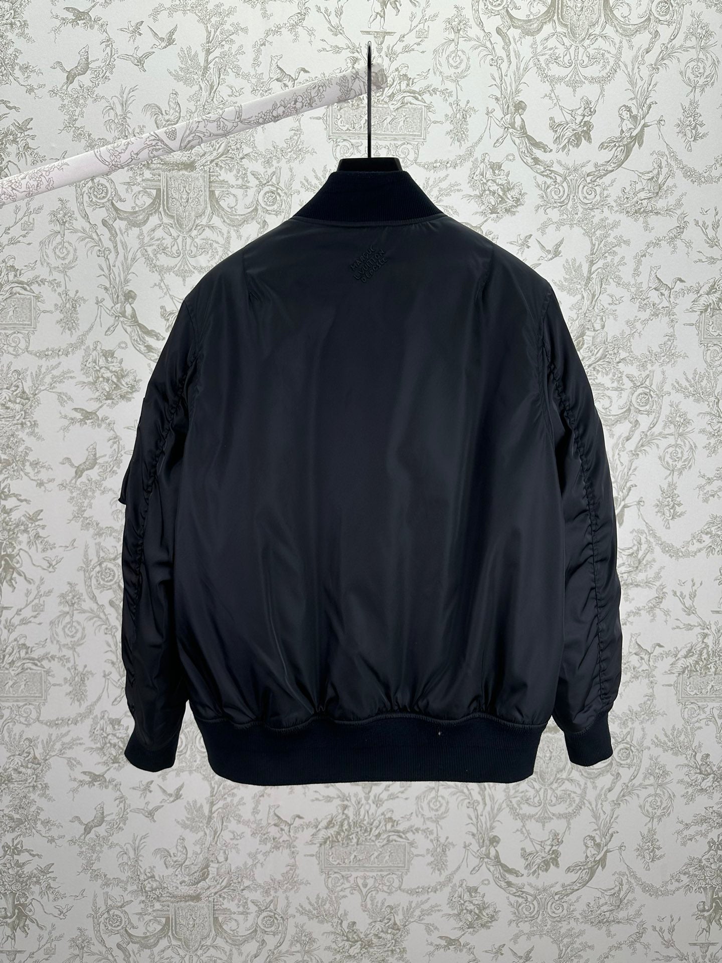 Navy bomber jacket back view with ribbed cuffs and waistband