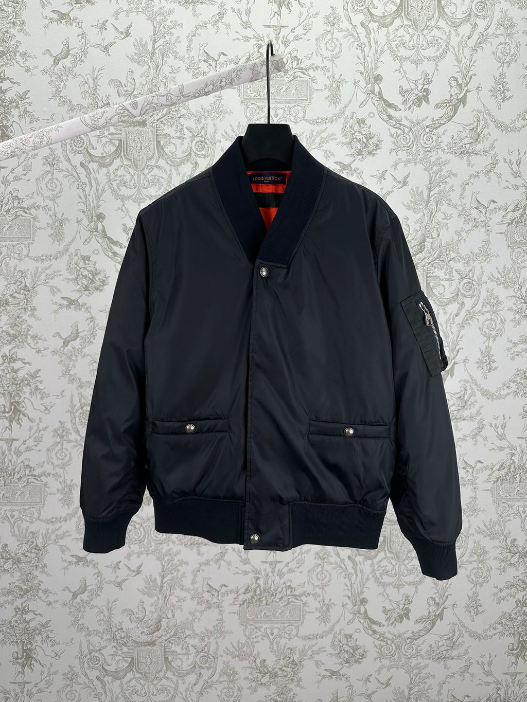 Navy bomber jacket with snap front, standing collar, and two chest pockets