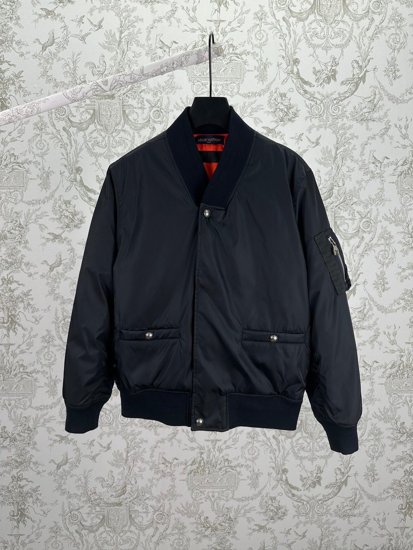 Navy bomber jacket with snap front, standing collar, and two chest pockets