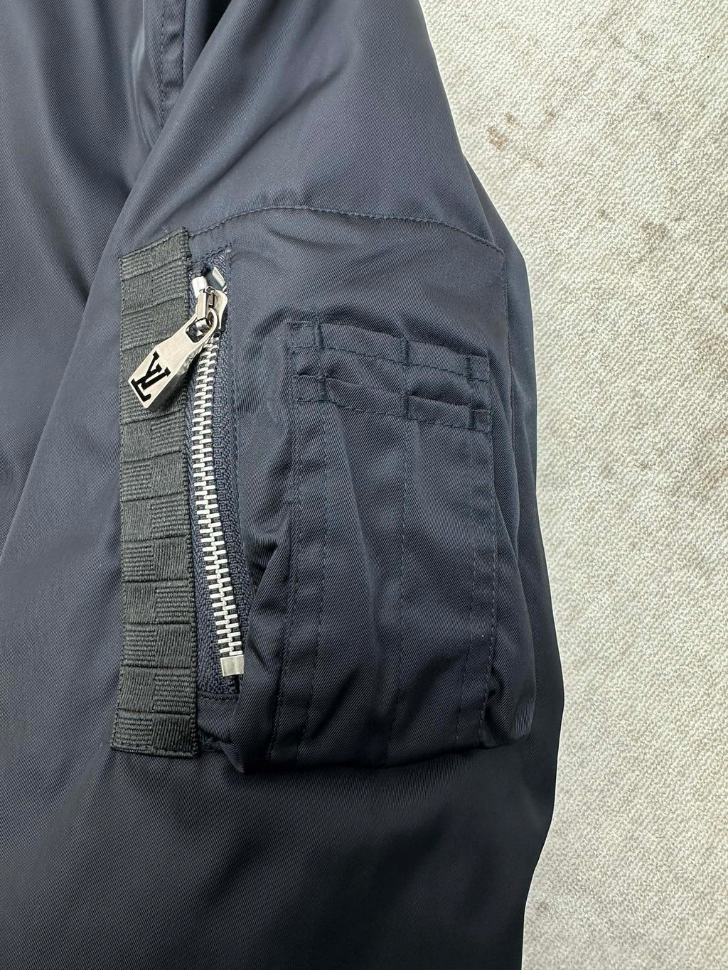 Navy bomber jacket with angled side pocket and visible zip detail