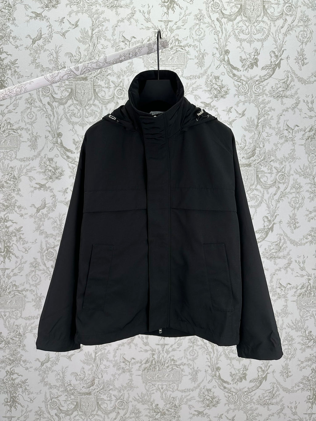 Black hooded jacket with front zipper and two flap pockets