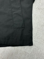 Dark jacket front with square flap pocket and stitched hem