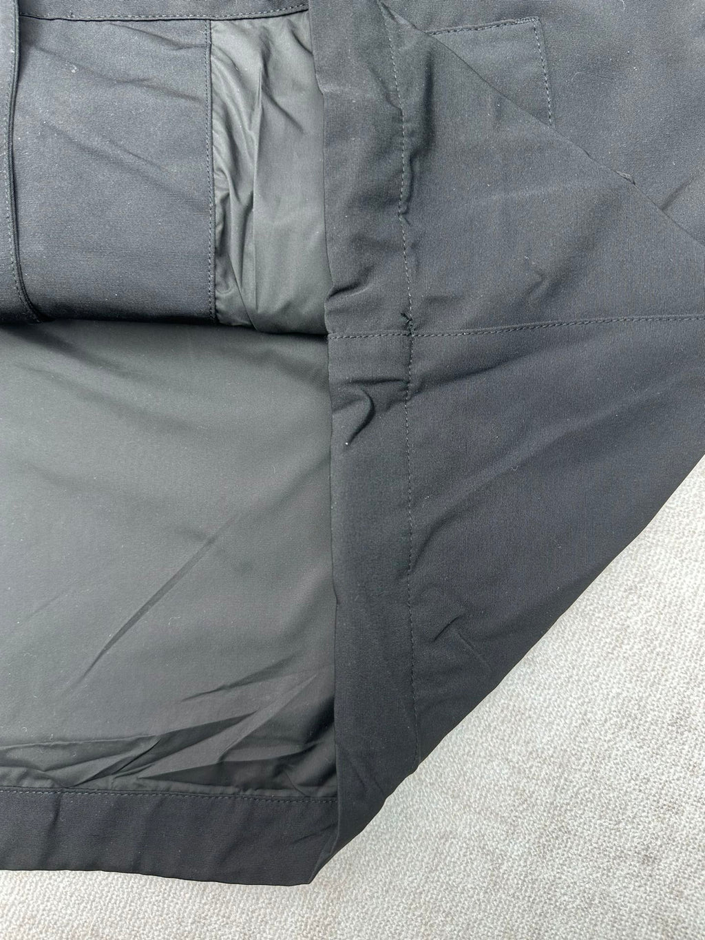 Dark jacket side panel with zipper trim and stitched seams