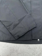 Dark jacket sleeve with seam lines and flap pocket detail
