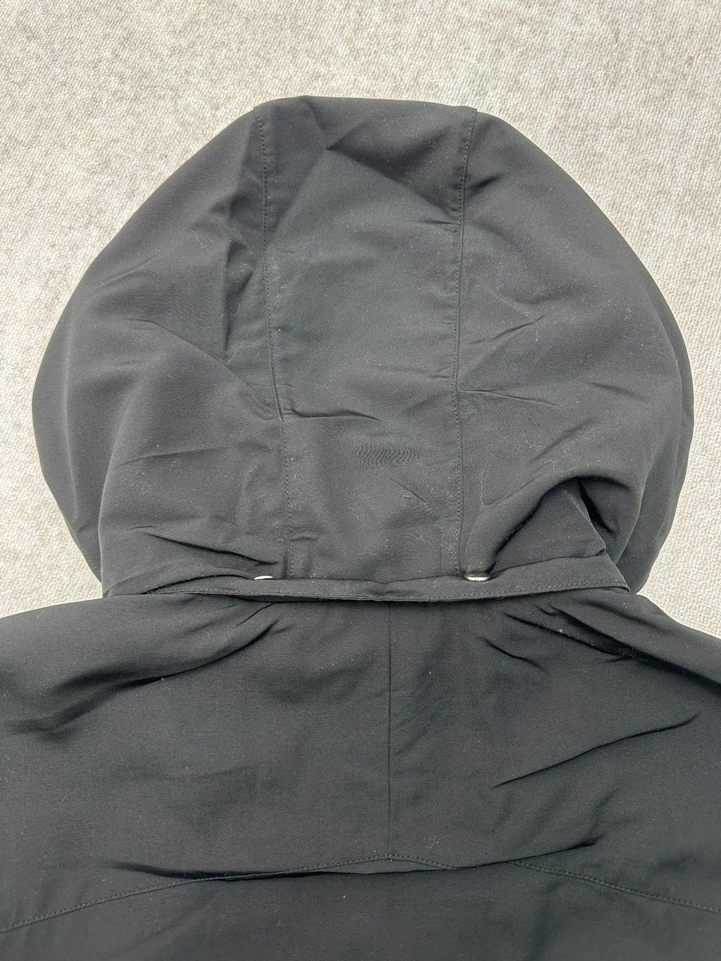 Dark hooded jacket with gathered hood and folded collar