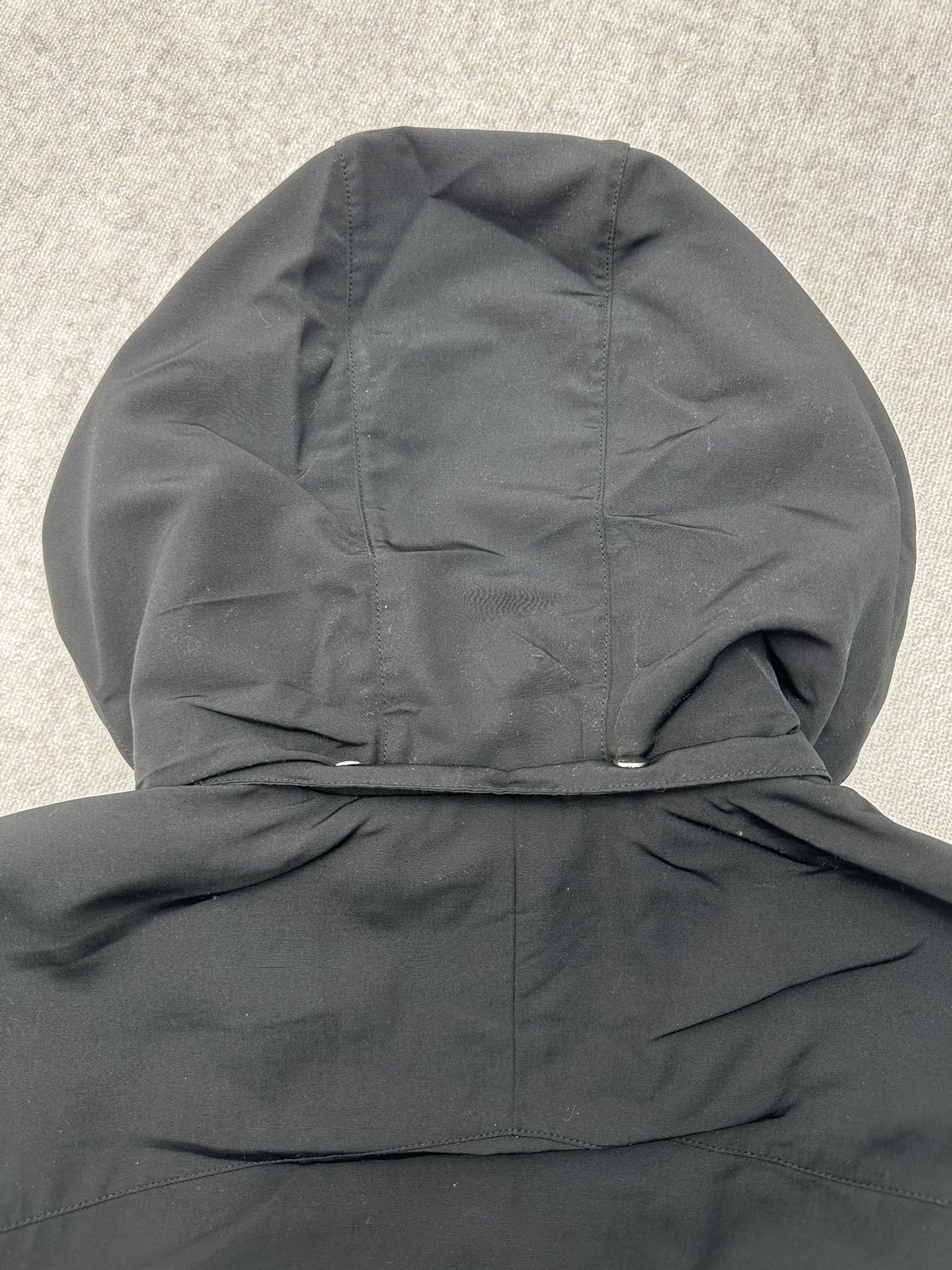 Dark hooded jacket with gathered hood and folded collar