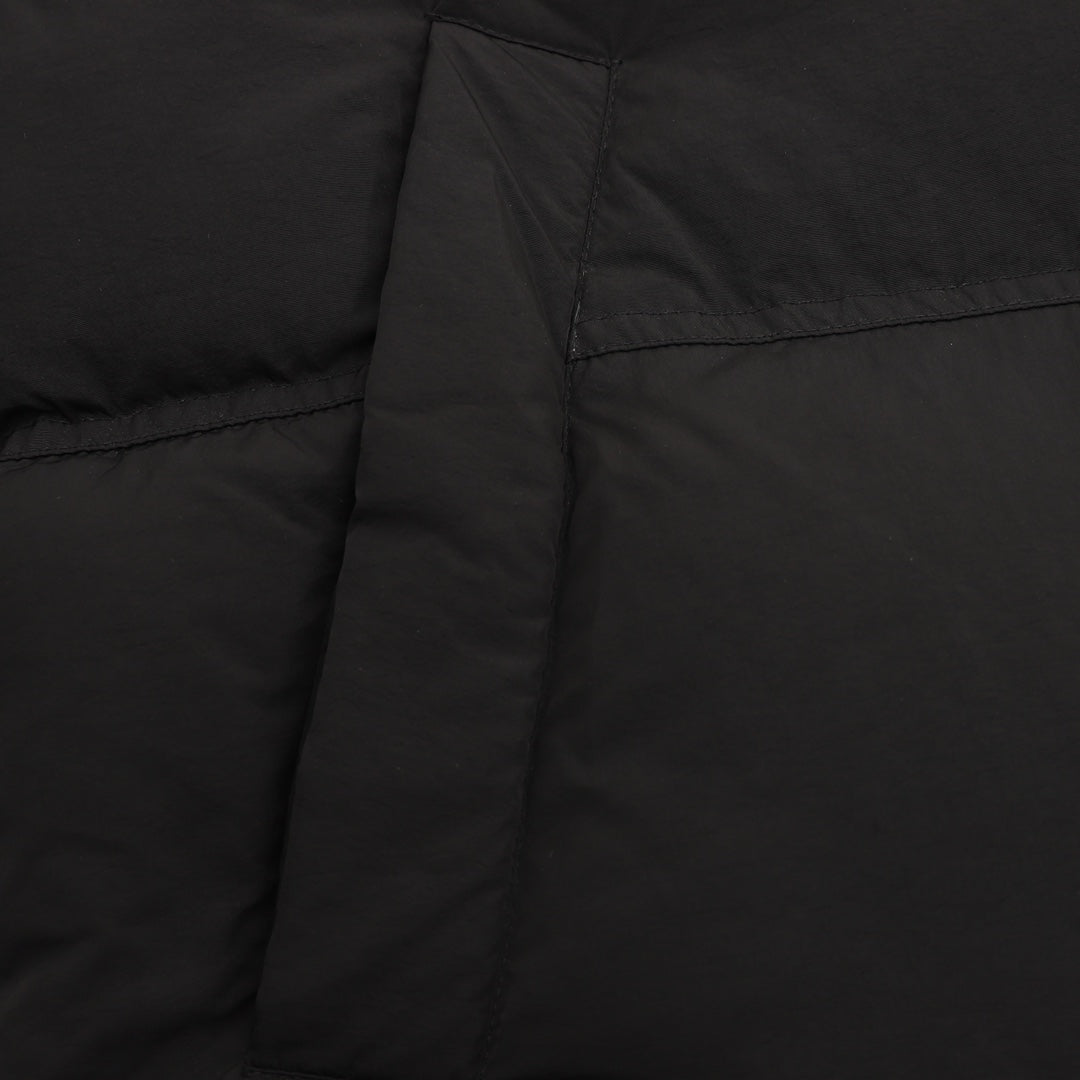 Black puffer jacket side panel with stitched seam detail