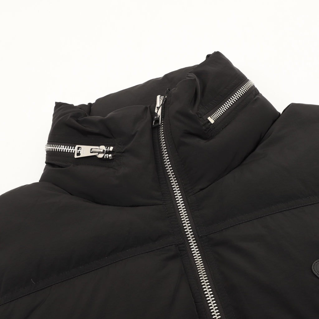 Black puffer jacket detail with front zipper and snap belt at chest