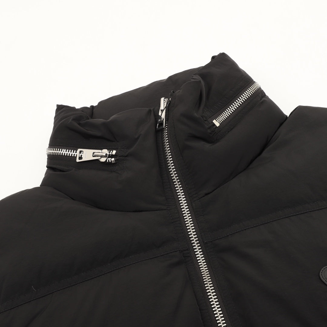Black puffer jacket detail with front zipper and snap belt at chest