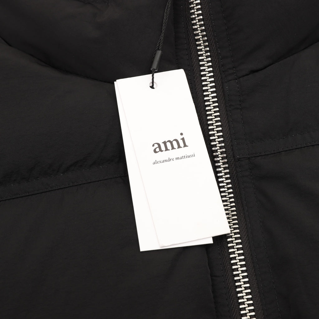 Black puffer jacket close-up of zipper with hanging retail tag