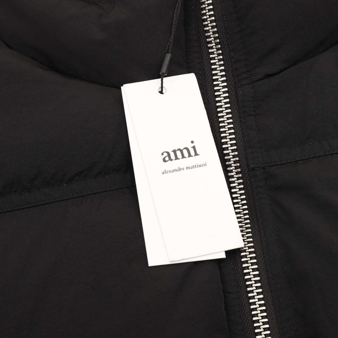 Black puffer jacket close-up of zipper with hanging retail tag