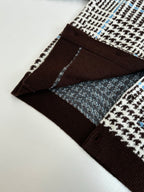 Detail of lower front panel: brown ribbed trim with check-pattern knit and buttons