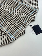Close-up of check-pattern knit with small blue accents on the cardigan