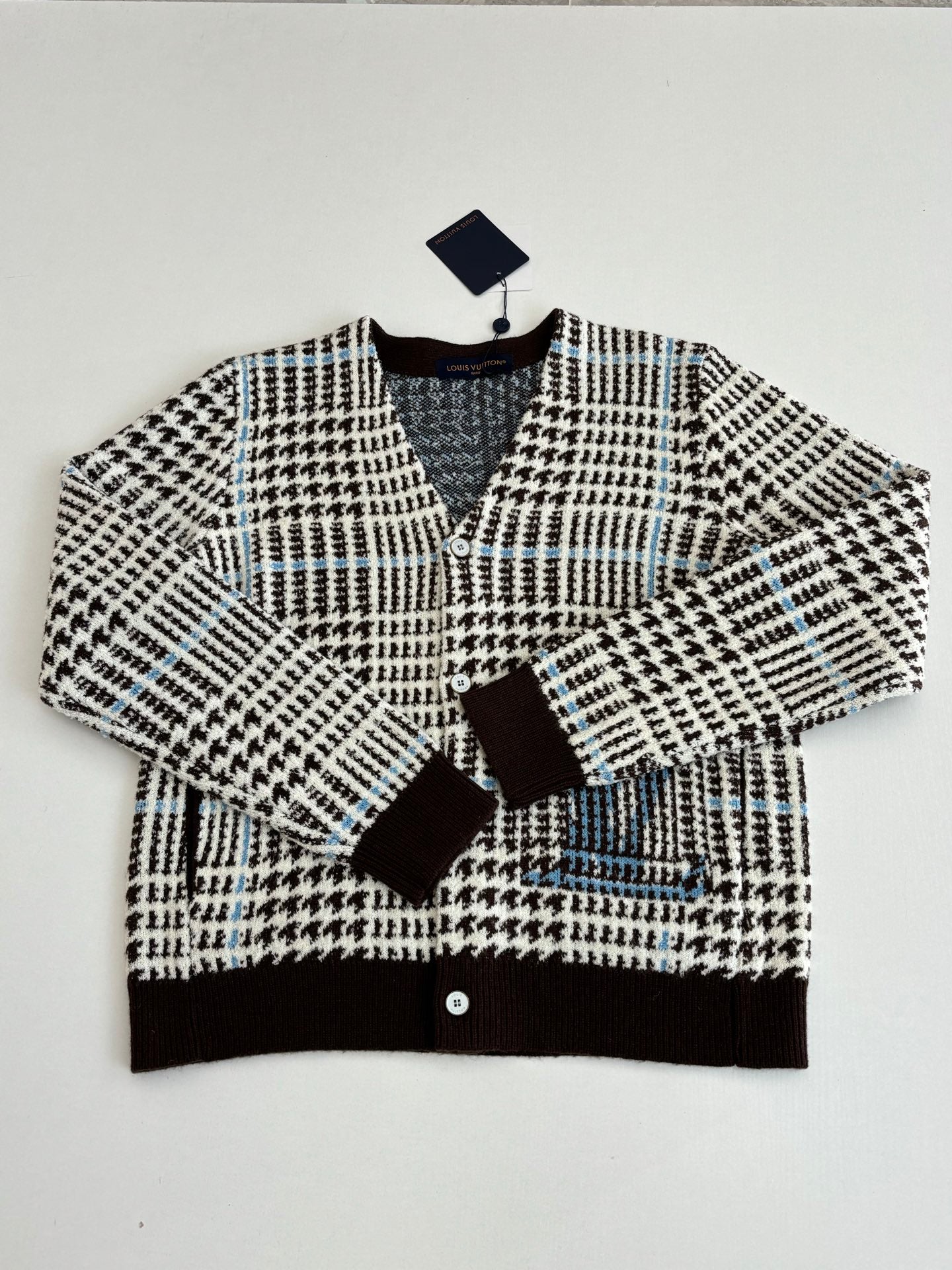 Button-front knit cardigan with black-and-white check pattern and brown ribbed trim