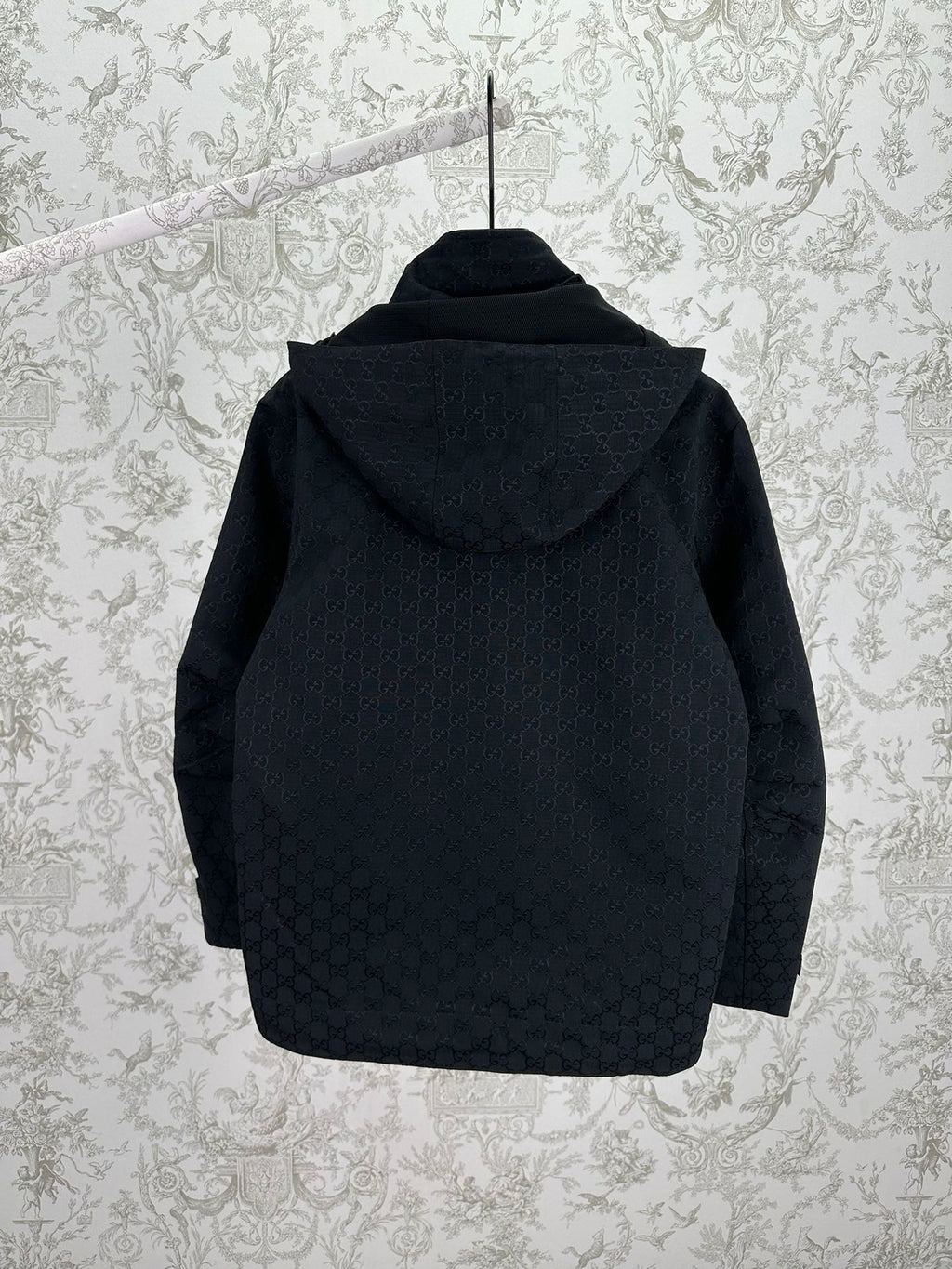 Gucci hooded long jacket back view, dark with allover GG pattern and hood