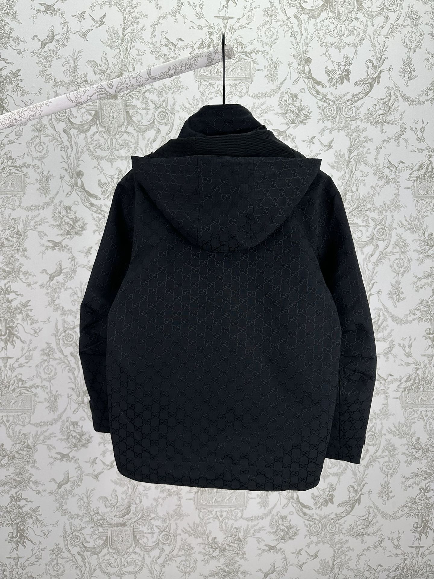 Gucci hooded long jacket back view, dark with allover GG pattern and hood