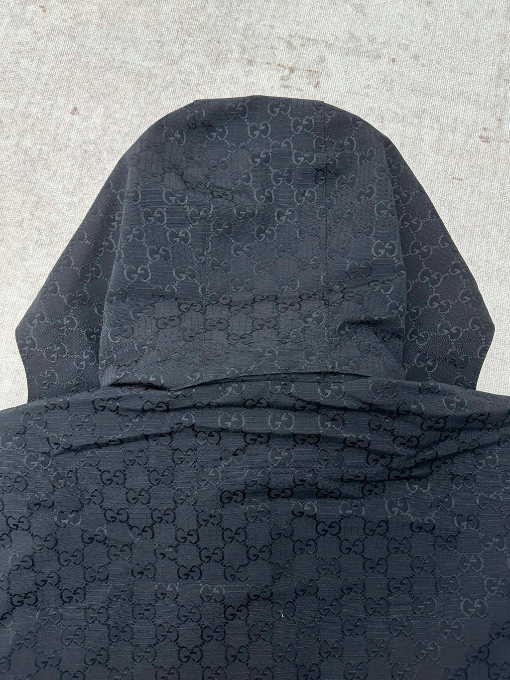 Gucci long jacket back view, dark with hood and allover GG monogram pattern