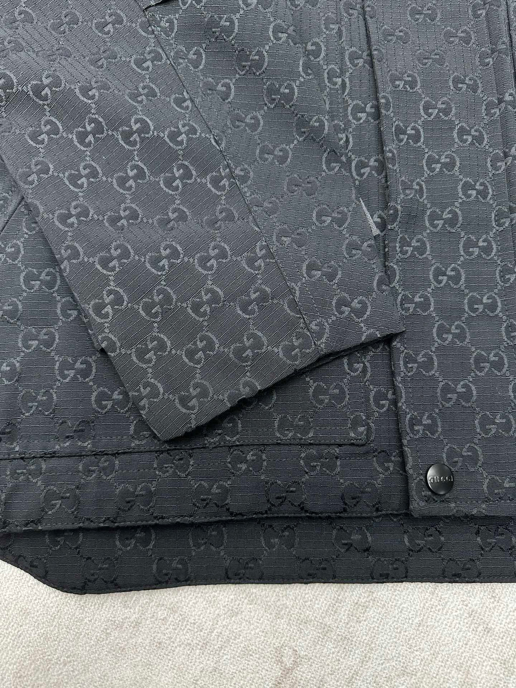 Gucci long jacket chest detail, dark GG pattern with flap pocket and snap strap